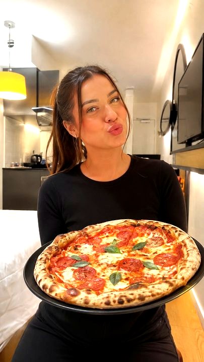 Créatrice de contenu UGC food présentant une pizza